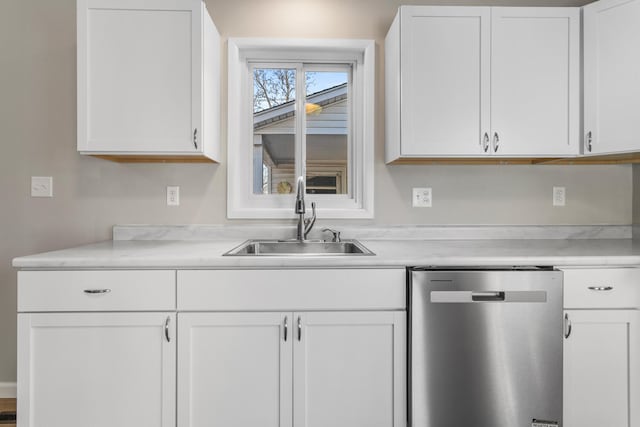 kitchen with light countertops, white cabinets, a sink, and stainless steel dishwasher