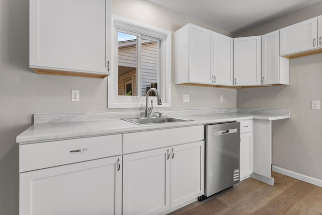 kitchen with a sink, white cabinets, light countertops, stainless steel dishwasher, and light wood-type flooring