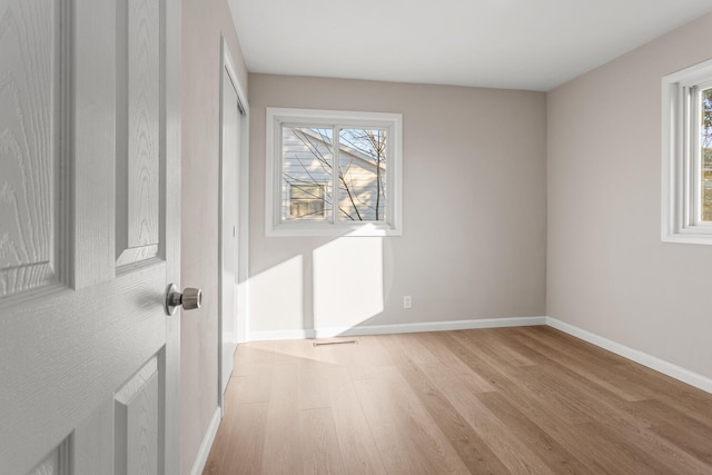 unfurnished room featuring baseboards and light wood finished floors