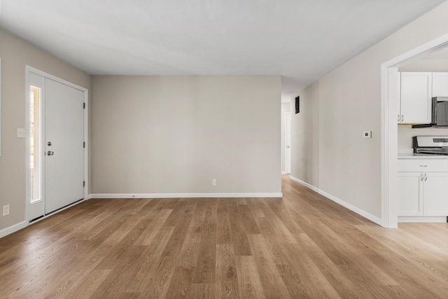 unfurnished living room with light wood finished floors and baseboards