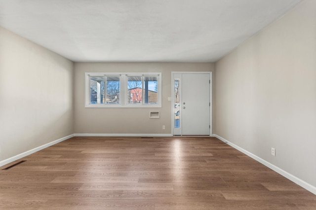 foyer with visible vents, baseboards, and wood finished floors