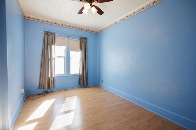 unfurnished room with a ceiling fan, light wood-type flooring, visible vents, and baseboards