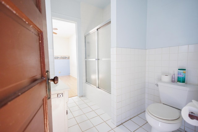 full bathroom with toilet, shower / bath combination with glass door, tile walls, and tile patterned floors