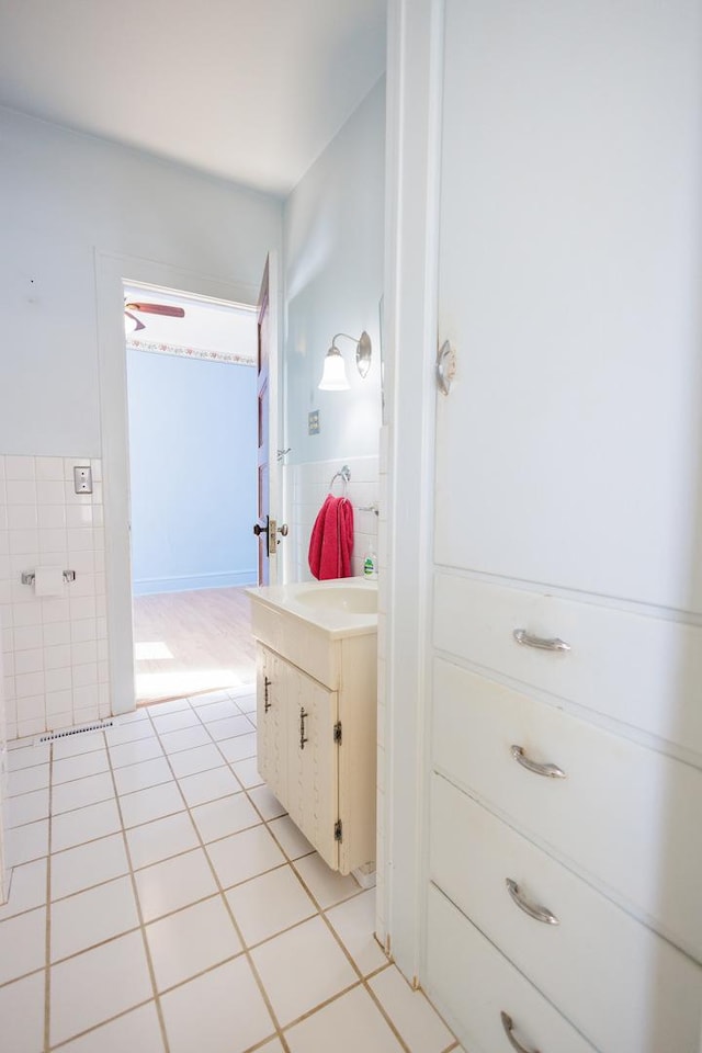 bathroom featuring a wainscoted wall, tile patterned flooring, vanity, and tile walls