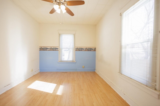 unfurnished room featuring light wood finished floors, a ceiling fan, and baseboards