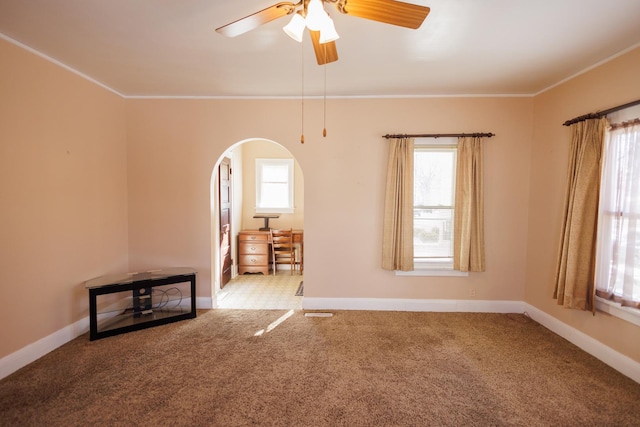 unfurnished room with crown molding, a wealth of natural light, and carpet flooring