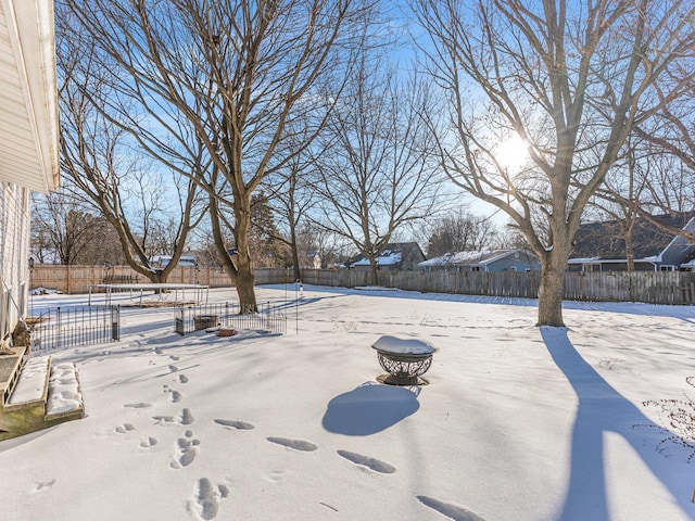 yard covered in snow featuring an outdoor fire pit and fence