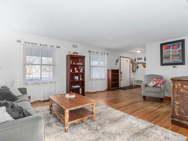 living room featuring a wealth of natural light, baseboards, and wood finished floors