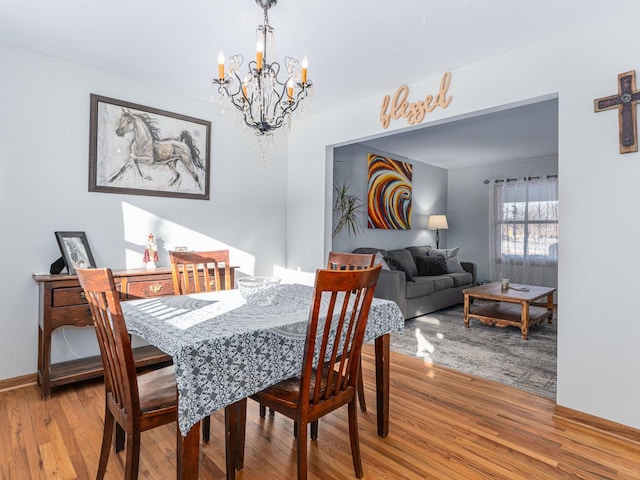 dining area with a notable chandelier and wood finished floors