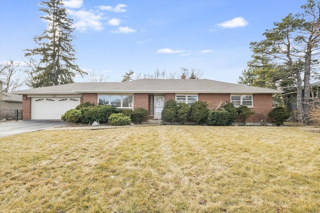 single story home featuring a garage, concrete driveway, brick siding, and a front lawn