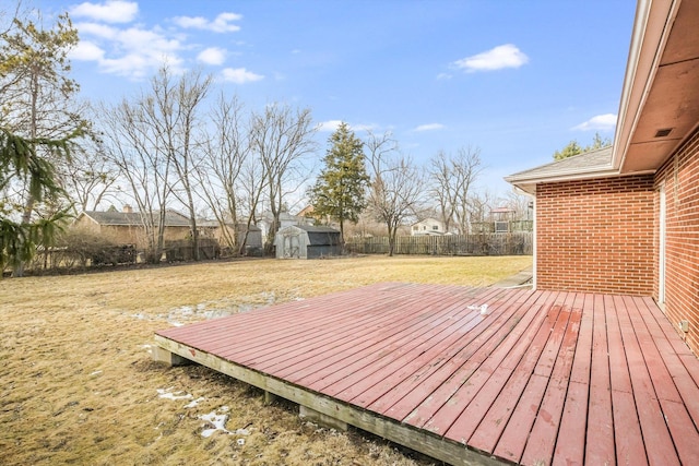 deck featuring a fenced backyard, a shed, an outdoor structure, and a yard