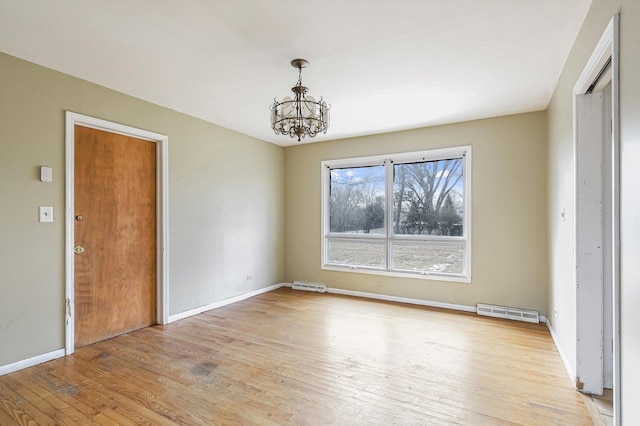 interior space with a chandelier, light wood-type flooring, visible vents, and baseboards