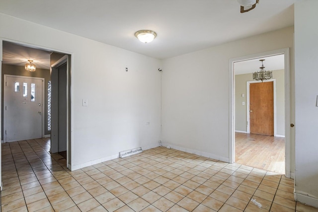 unfurnished room with light tile patterned flooring, visible vents, and an inviting chandelier