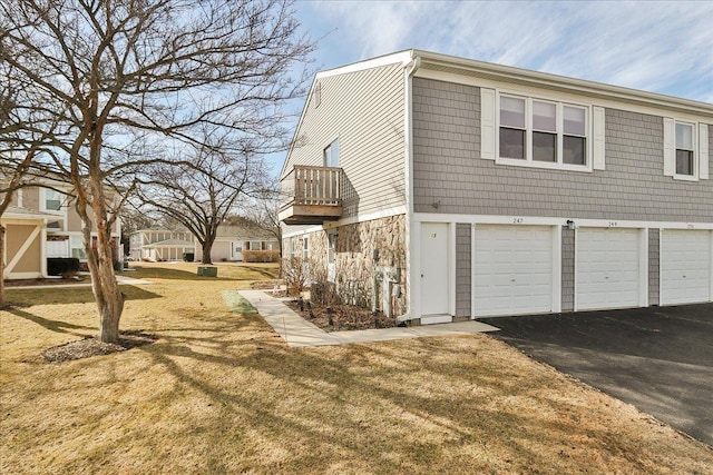 view of home's exterior with aphalt driveway and a yard