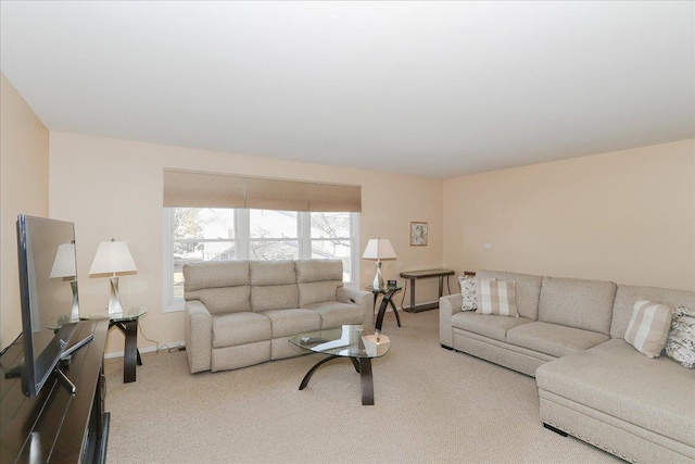 carpeted living area featuring baseboards