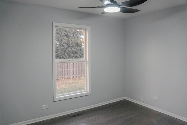 unfurnished room featuring visible vents, baseboards, ceiling fan, and dark wood-type flooring