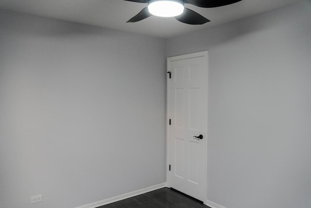 empty room with ceiling fan, baseboards, and dark wood-type flooring