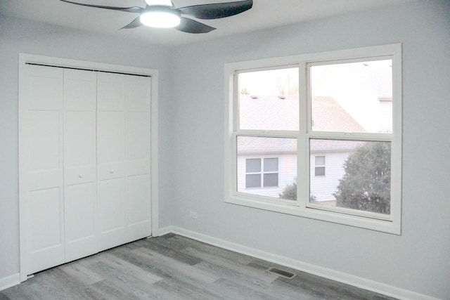 unfurnished bedroom featuring light wood-type flooring, a closet, visible vents, and baseboards