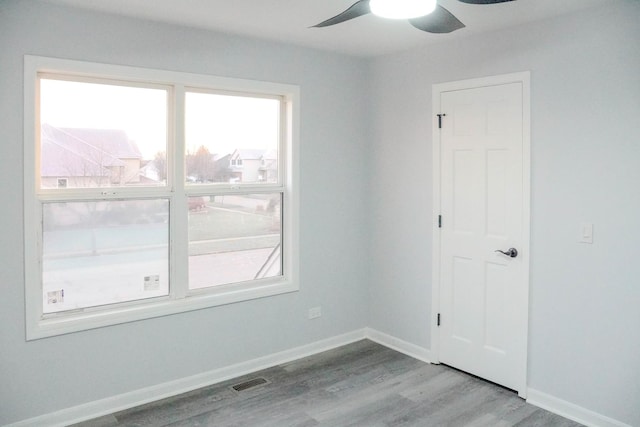 unfurnished room featuring light wood-type flooring, visible vents, ceiling fan, and baseboards