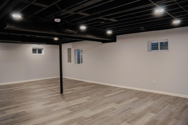 finished below grade area featuring visible vents, baseboards, and wood finished floors