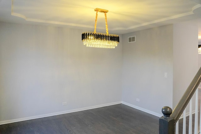 unfurnished room featuring baseboards, visible vents, a tray ceiling, and dark wood-style flooring