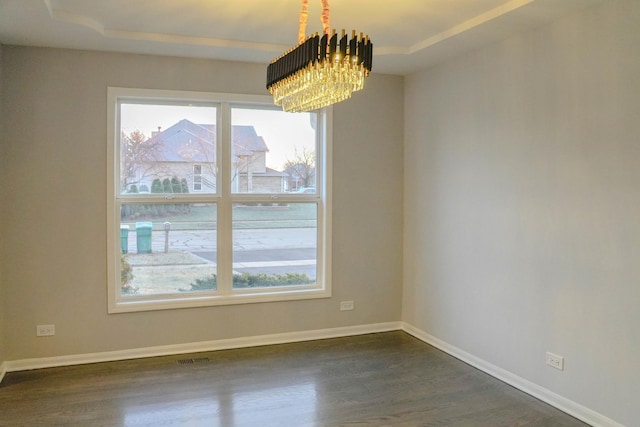 unfurnished room with dark wood-style floors, a chandelier, a wealth of natural light, and baseboards