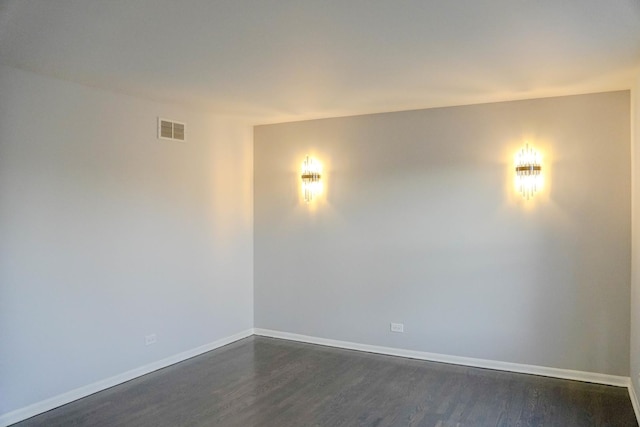 unfurnished room featuring dark wood-style floors, baseboards, and visible vents