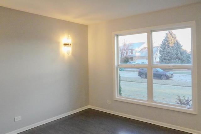 empty room featuring dark wood-style floors and baseboards