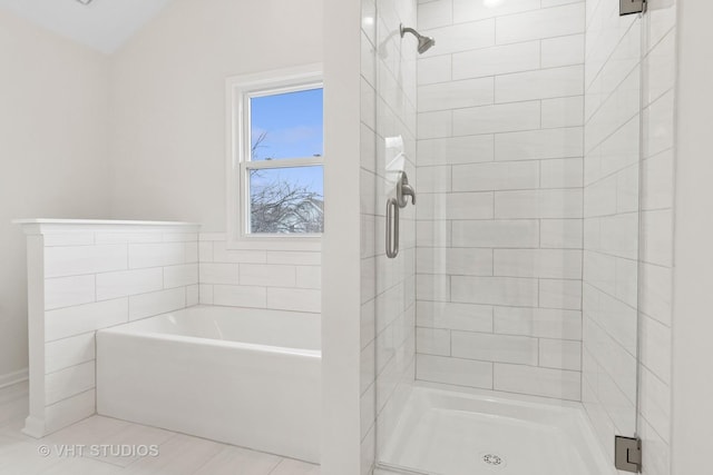 bathroom with a stall shower and a garden tub