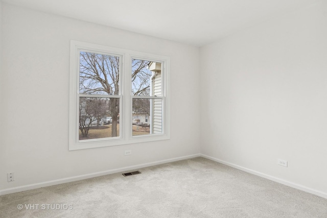 unfurnished room featuring carpet, visible vents, and baseboards