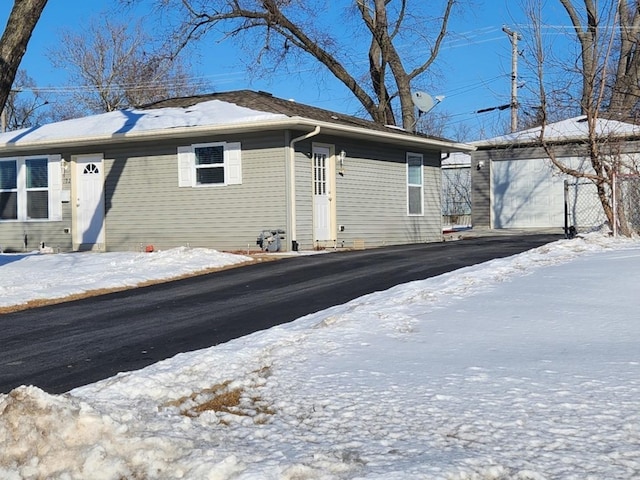 view of snowy exterior featuring an outbuilding and a garage