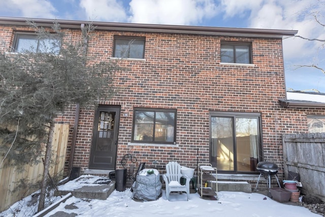 view of front of property featuring brick siding and fence