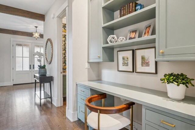 interior space with baseboards, french doors, beam ceiling, dark wood-style floors, and built in desk