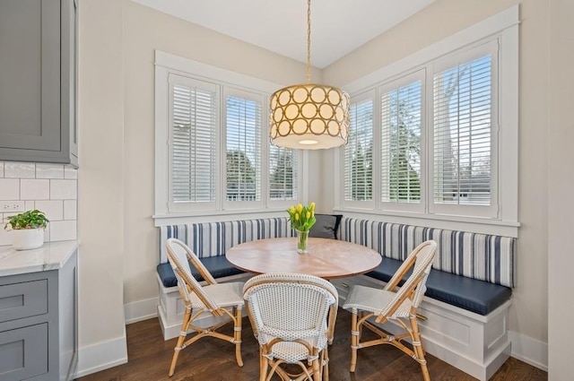 dining room featuring baseboards, breakfast area, and dark wood finished floors