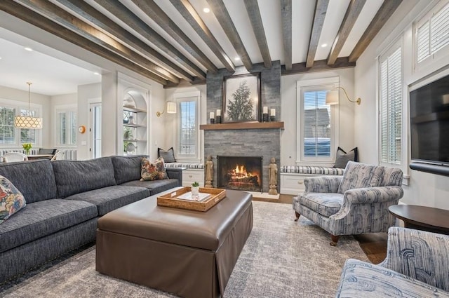 living area with a stone fireplace, beam ceiling, a wealth of natural light, and recessed lighting