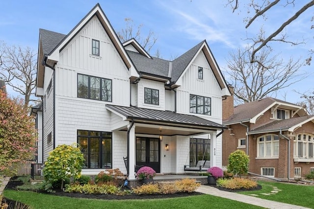 modern farmhouse style home featuring a shingled roof, a standing seam roof, metal roof, and board and batten siding