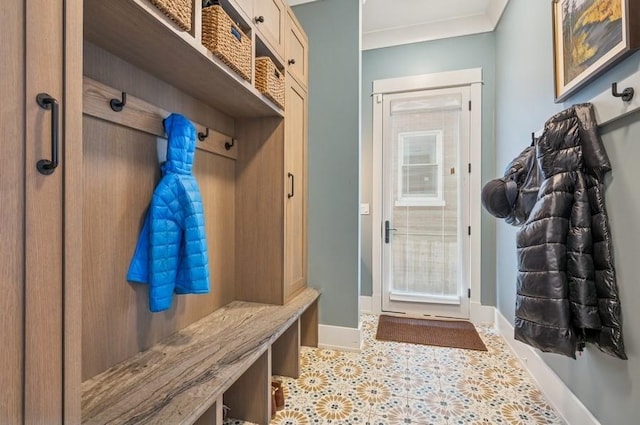 mudroom with ornamental molding, baseboards, and tile patterned floors