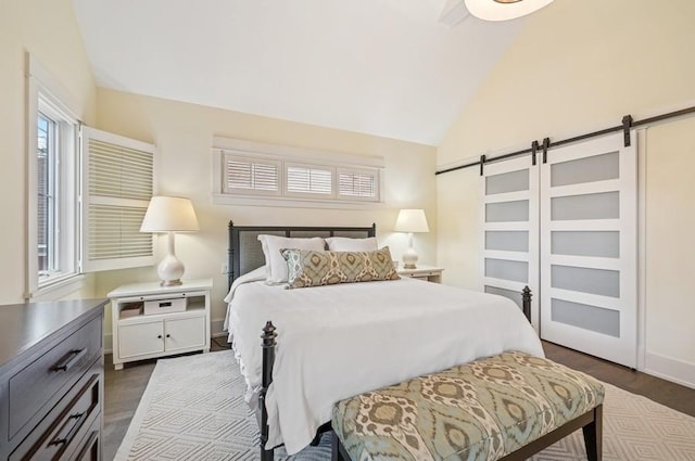 bedroom with a barn door, baseboards, vaulted ceiling, and dark wood-style flooring