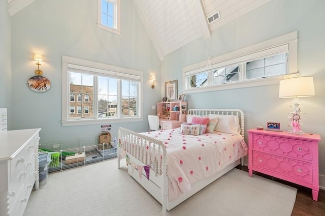 bedroom featuring visible vents, high vaulted ceiling, and beam ceiling