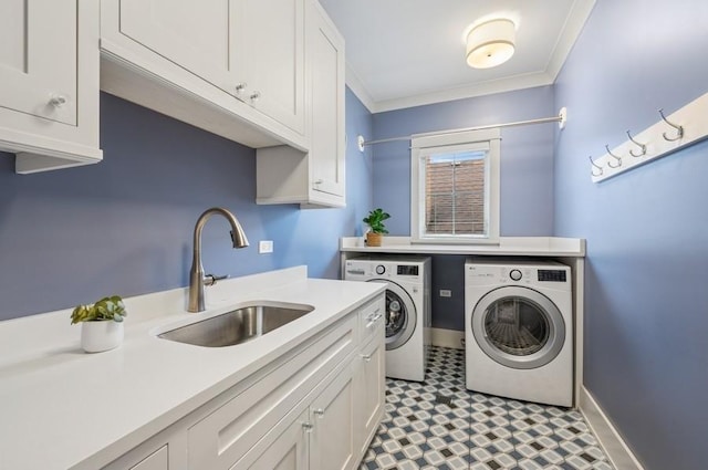 laundry area featuring light floors, cabinet space, ornamental molding, a sink, and independent washer and dryer