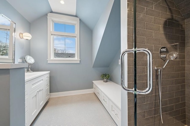 bathroom featuring a wealth of natural light, lofted ceiling, tiled shower, and baseboards