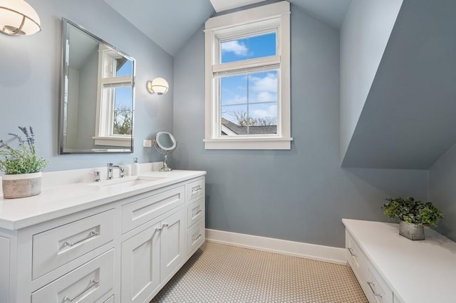 bathroom with lofted ceiling, vanity, a wealth of natural light, and baseboards