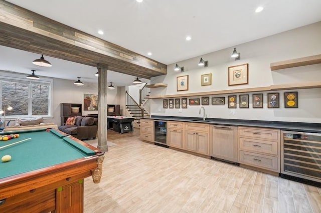 game room with light wood-style floors, beverage cooler, indoor wet bar, and a sink