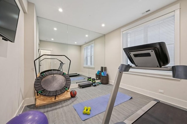 workout area featuring recessed lighting, visible vents, baseboards, and wood finished floors