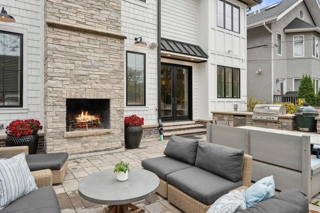 view of patio featuring exterior kitchen, french doors, a grill, and an outdoor living space with a fireplace