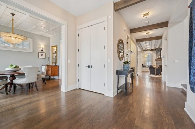 entrance foyer with plenty of natural light, baseboards, dark wood finished floors, and beamed ceiling