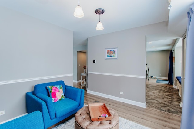 sitting room with light wood finished floors, recessed lighting, and baseboards