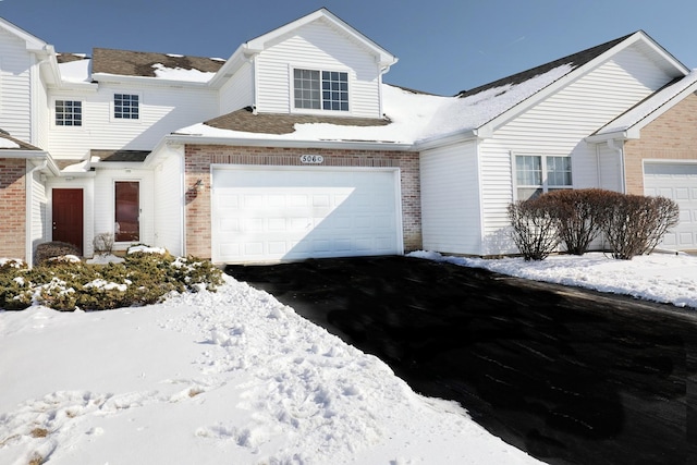 view of front of home featuring aphalt driveway and brick siding