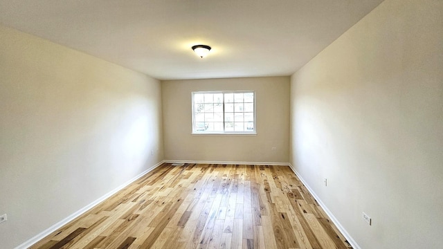 unfurnished room with light wood-style floors and baseboards
