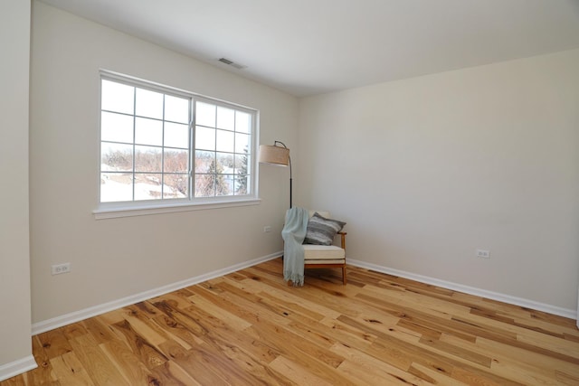 unfurnished room with visible vents, baseboards, and wood finished floors